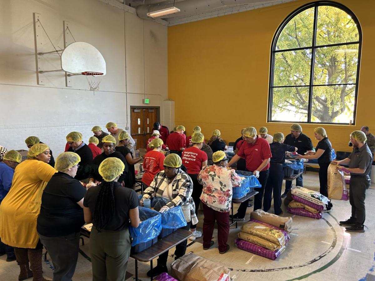 Volunteers shown packing meals for people in need.