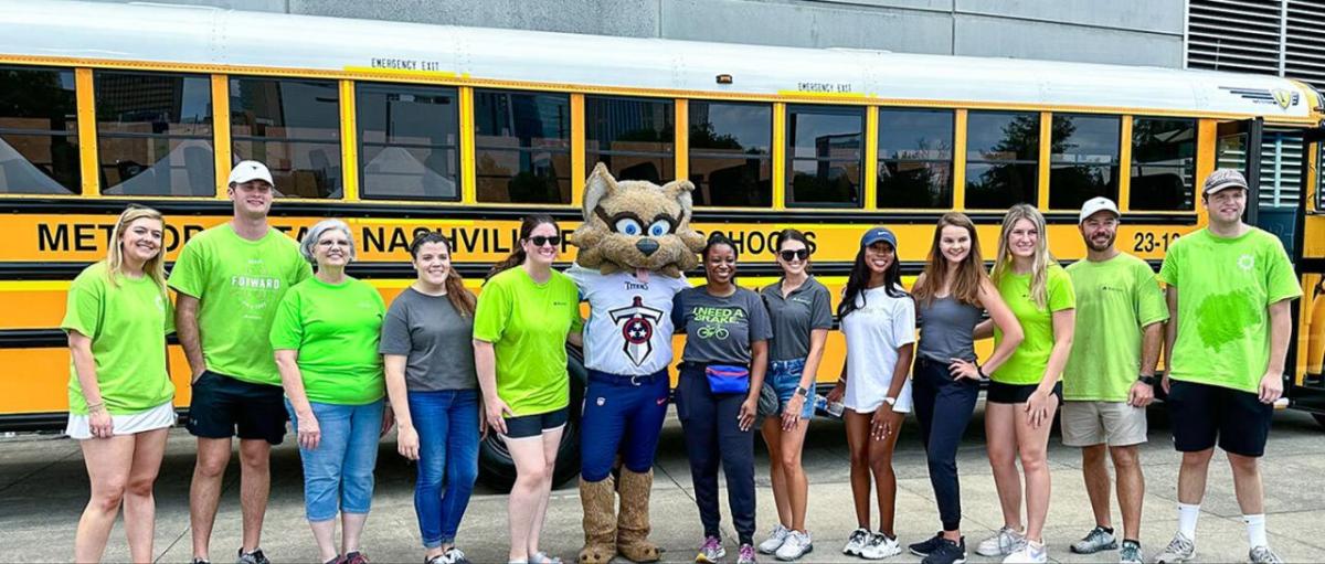 People posed in a line in front of a school bus.