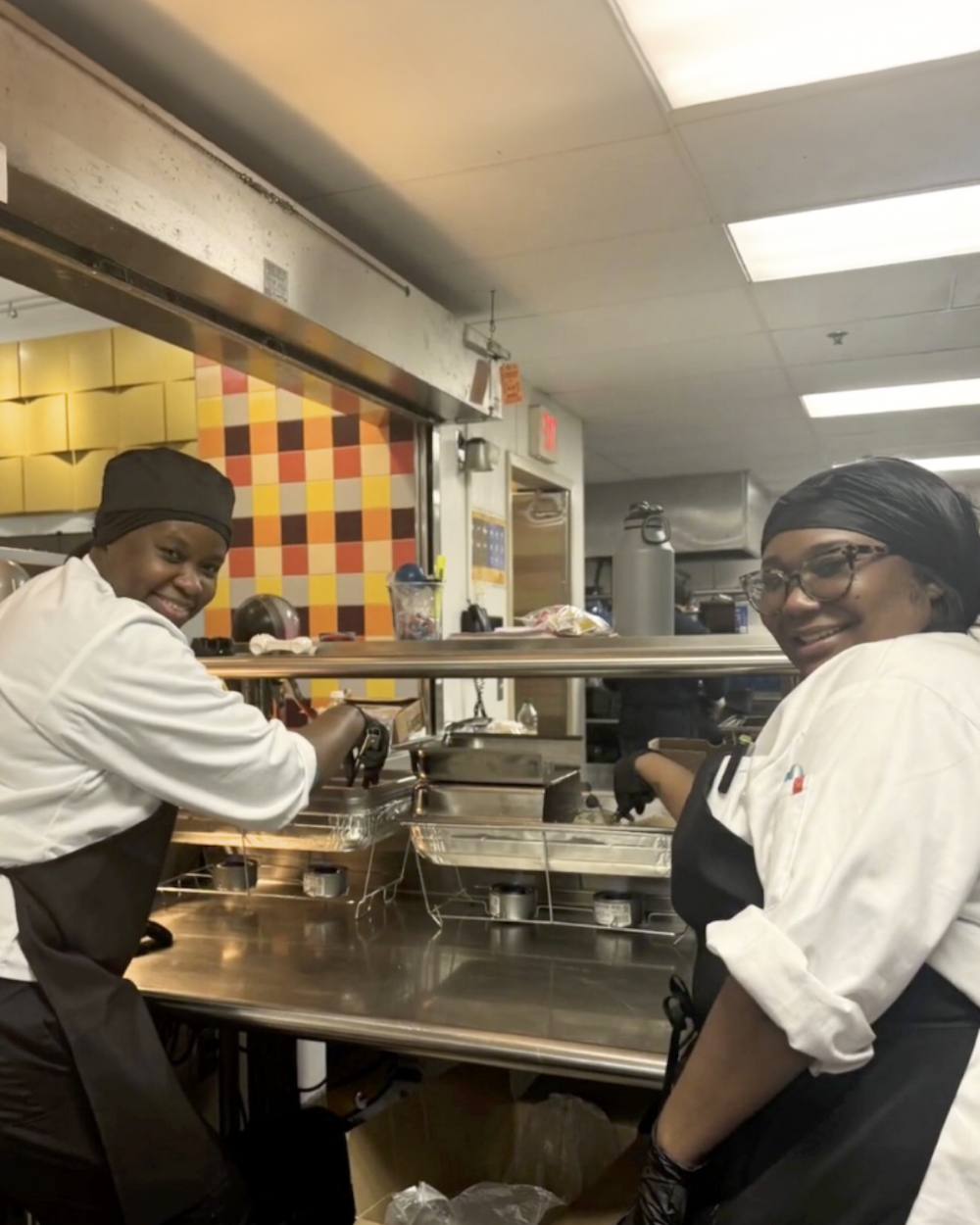 two people working in kitchen