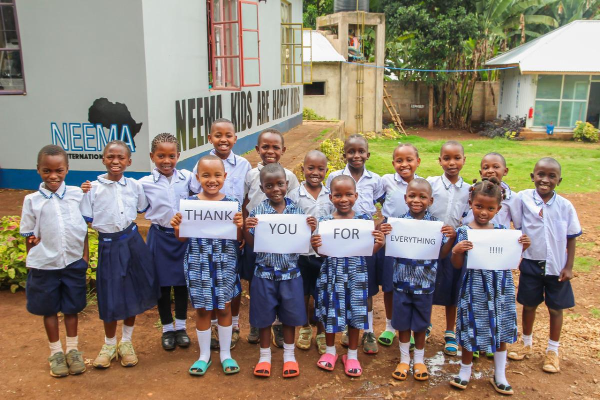 Group of children holding a sign reading, "Thank you for everything!!!"