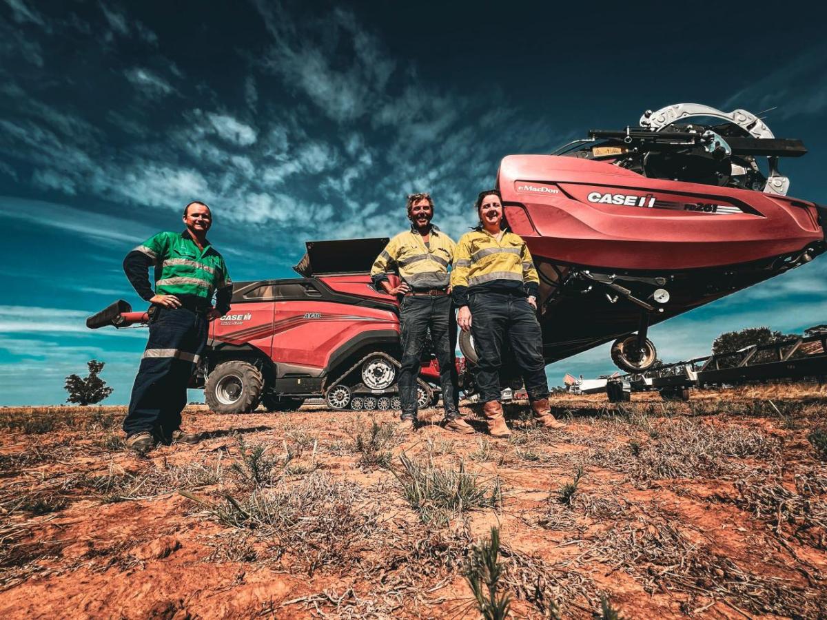 Three people standing outside near CASE IH equipment