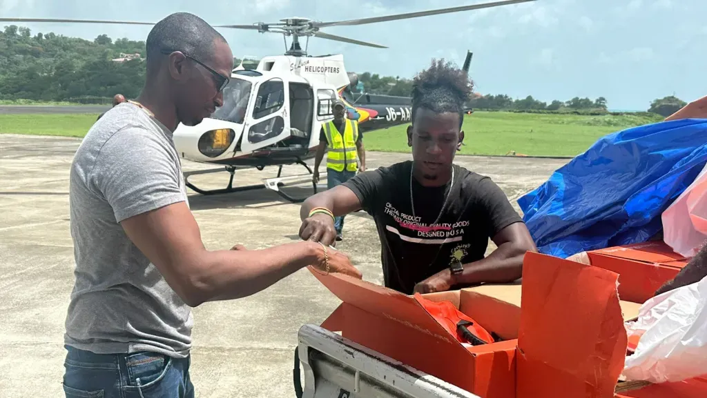 Members of the Office of Eastern Caribbean States, or OECS, load Direct Relief field medic packs and a hurricane preparedness pack into a helicopter in St. Lucia, in preparation for transport to St. Vincent and the Grenadines. (Photo courtesy of OECS)
