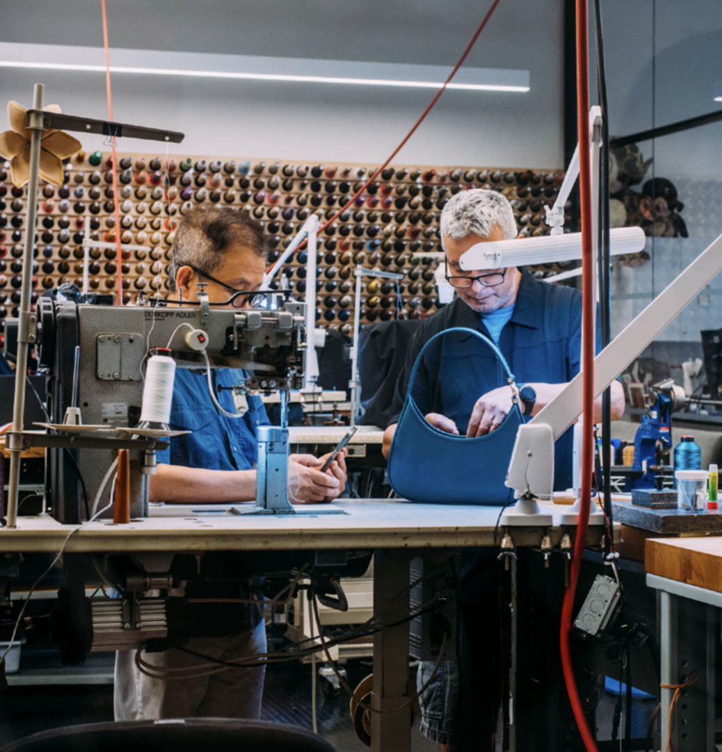 two people working on a handbag