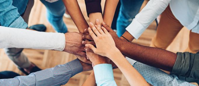 Hands in a circle on top of each other; as in partnership or an oath.