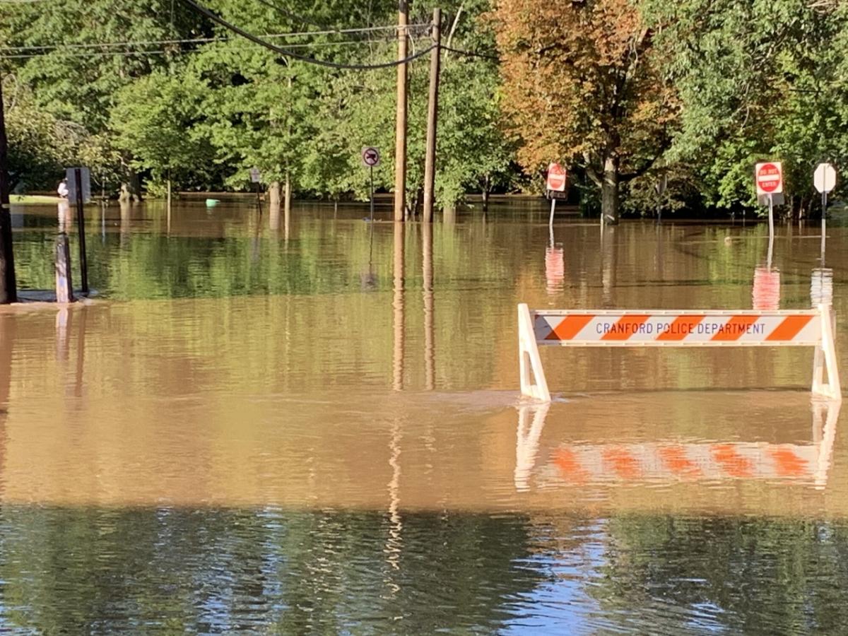 Flooded road with safety hurdle. Safety hurdle is nearly underwater.