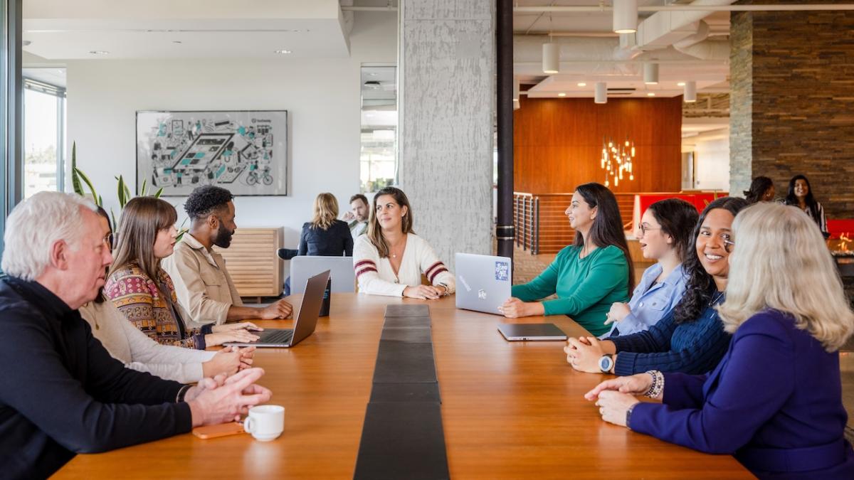 GoDaddy team members shown at a long table working.