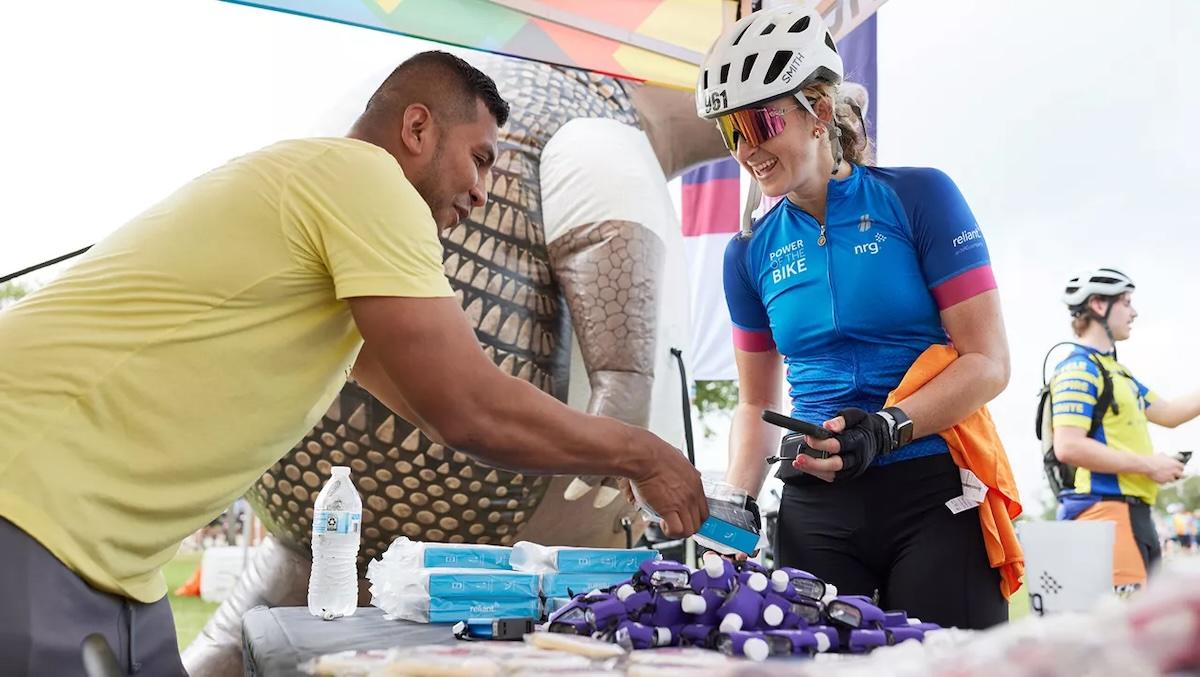 Pedal Power rider shown at a booth with supplies.