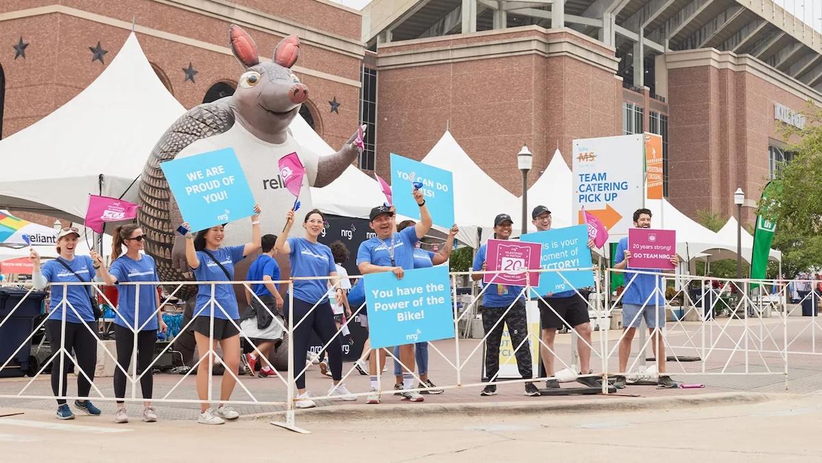 Spectators and Armadillo mascot cheering on the riders.