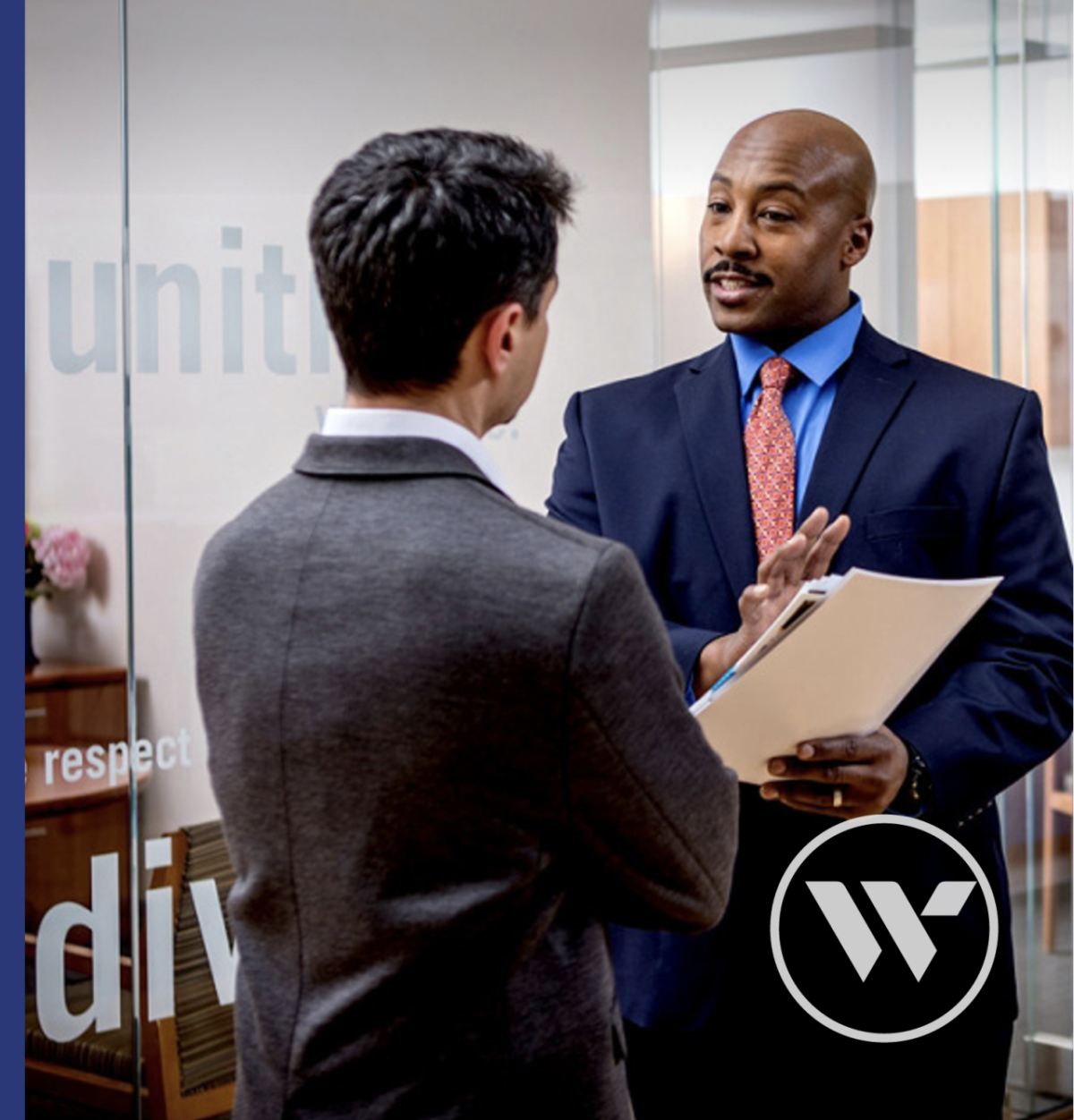 Two people stood talking inside an office