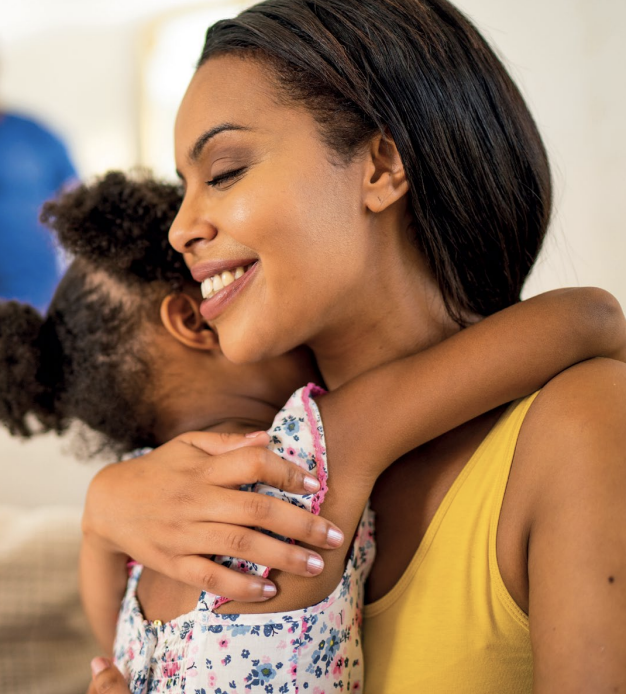 An adult and child hugging 