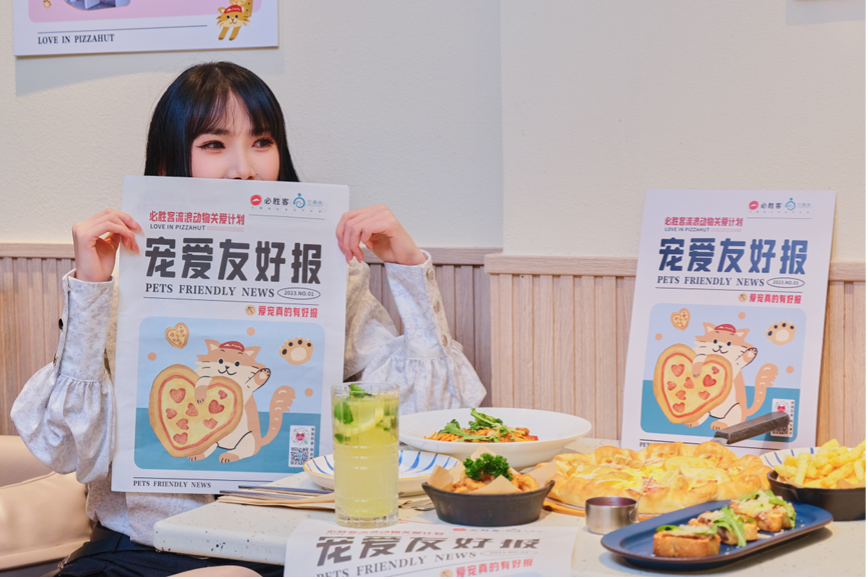 Person sat at a restaurant table holding up a newspaper