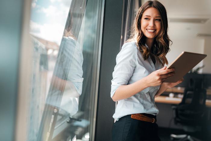 Woman in an office holding a clipboard.