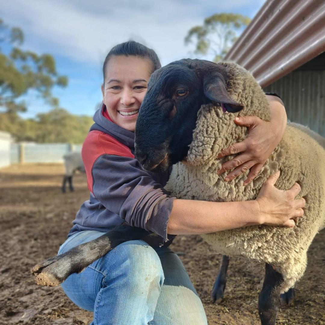 Rachel Chirgwin, hugging a sheep