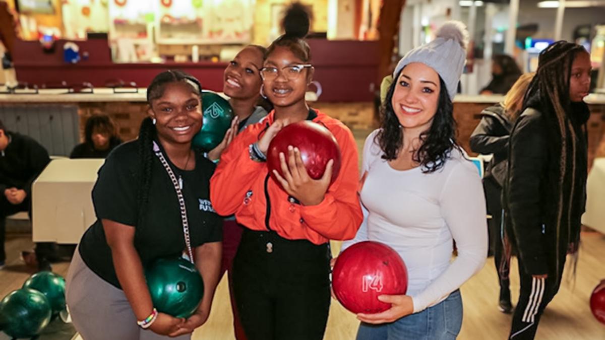 Rebecca shown with two mentees at a bowling alley.