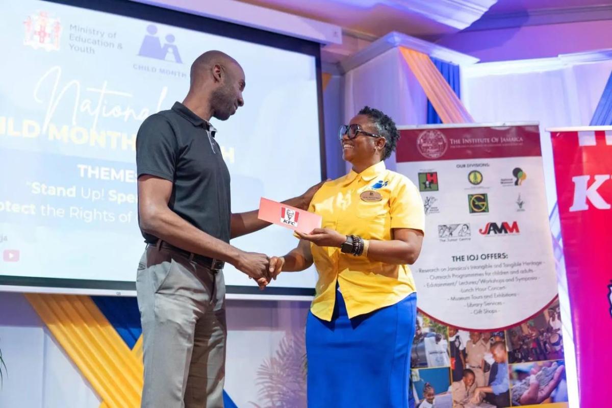 Restaurants of Jamaica Brand Manager Andrei Roper (left) presents a symbolic cheque to National Child Month Committee Chairperson Nicole Patrick-Shaw, during the National Child Month Launch.