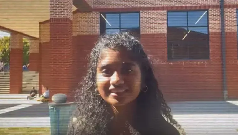 Photo of a student in front of a building 