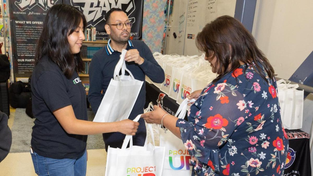 A person handing out ProjectUP bags.