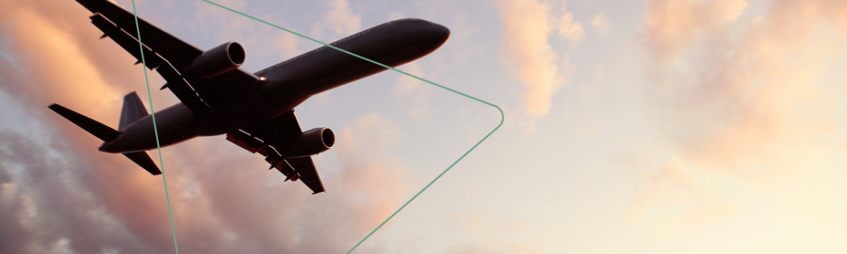 An airplane in the sky, a setting sun off screen.