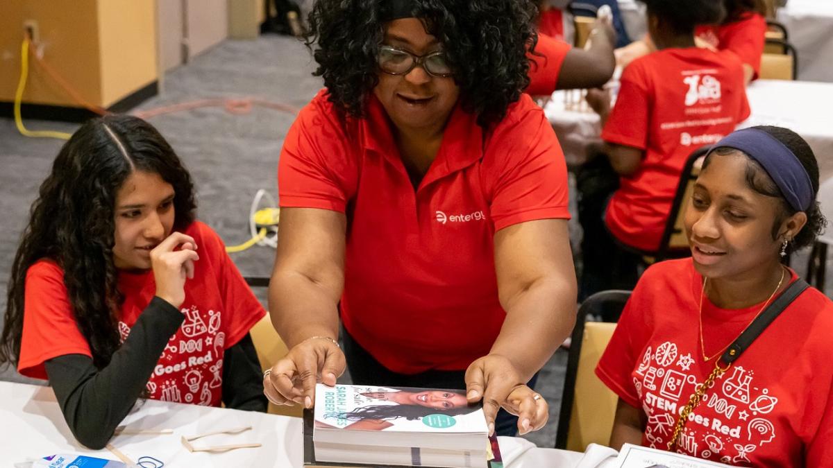 instructor working with two students on STEM activity