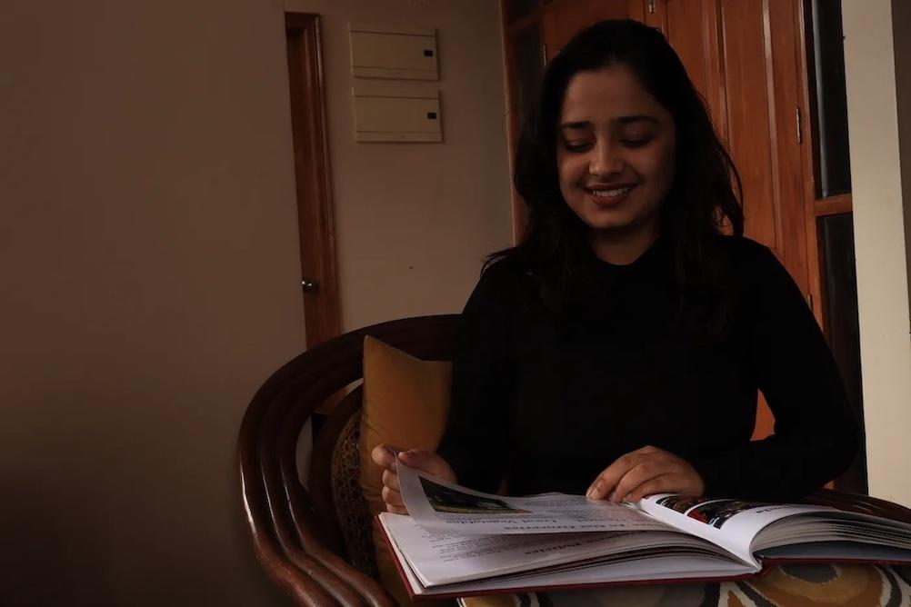 Sadbhavana Bhardwaj shown reading a book while seated at a table.