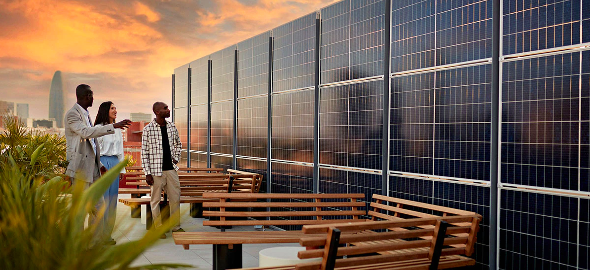 3 people standing in front of a wall of solar panels