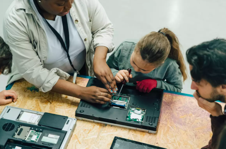 Students taking apart a laptop computer