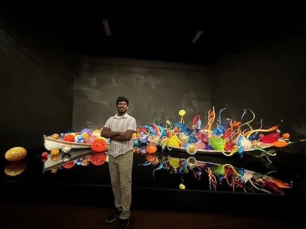 Srinivasa Rao Aharma shown in front of a traditional Indian vessel.