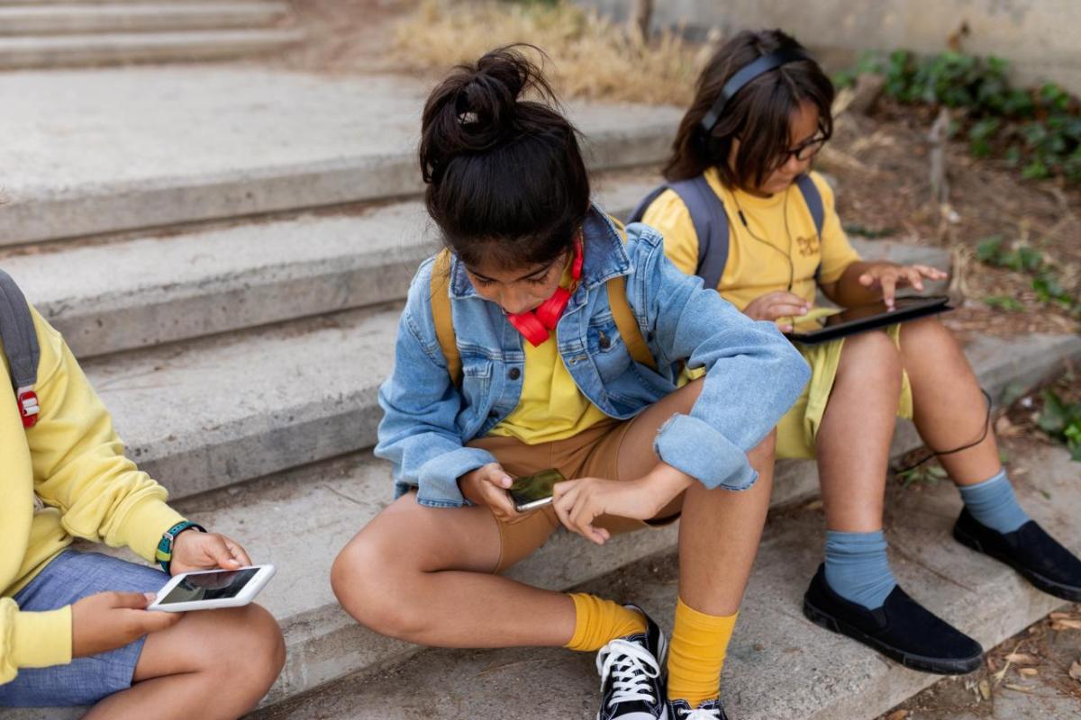 Students in uniform on their devices