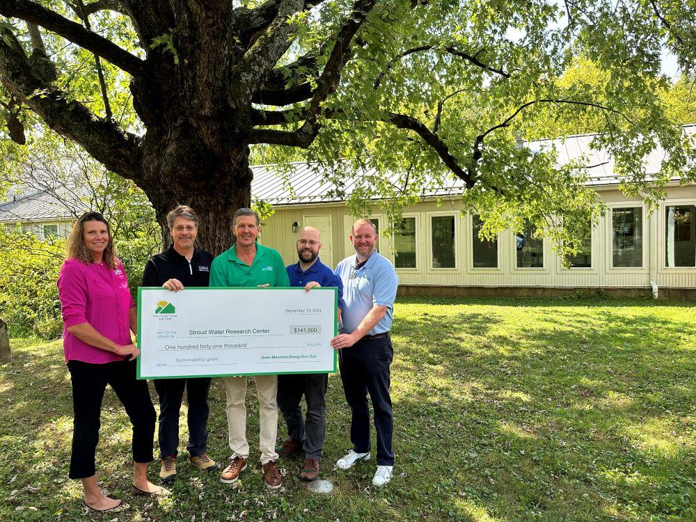 Group of Stroud Water Research Center team and Green Mountain Energy team pose with a $141,000 sustainability grant check at Stroud Water Research Center facility in Avondale, PA.