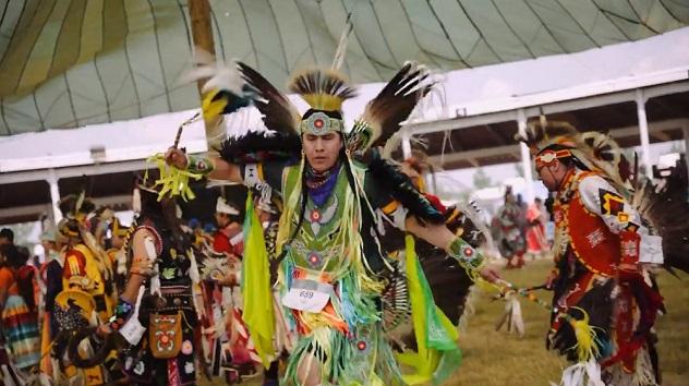 people wearing traditional clothing, crafted from beads and feathers