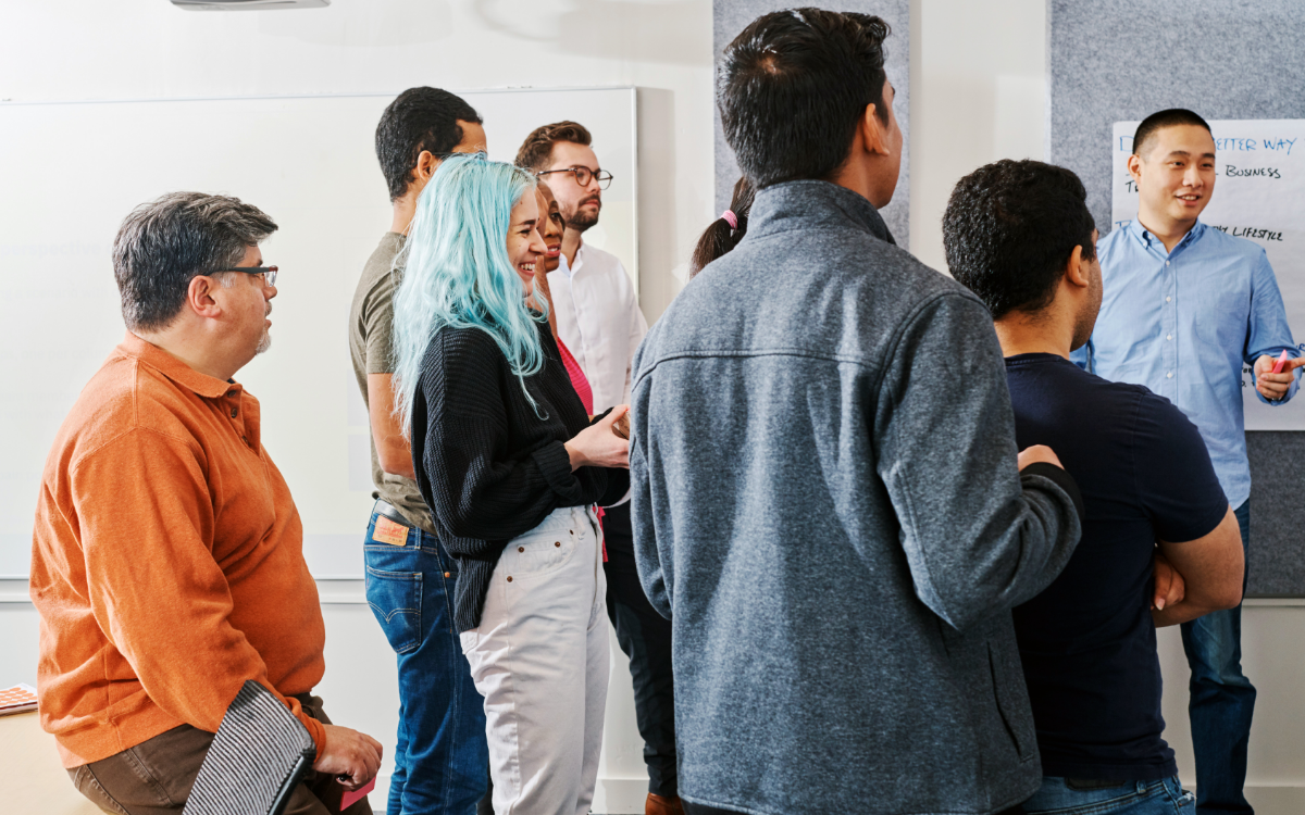 A group of people watching a presenter in front of them.