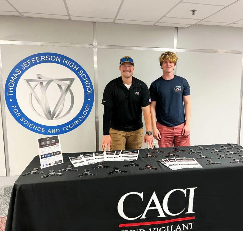 Two people standing behind a table