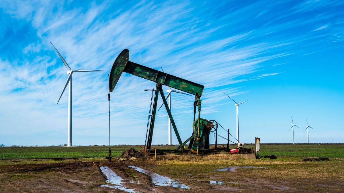 oil rig with windmill in the background