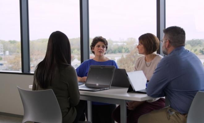 Lynn Penny in a meeting with 3 other people