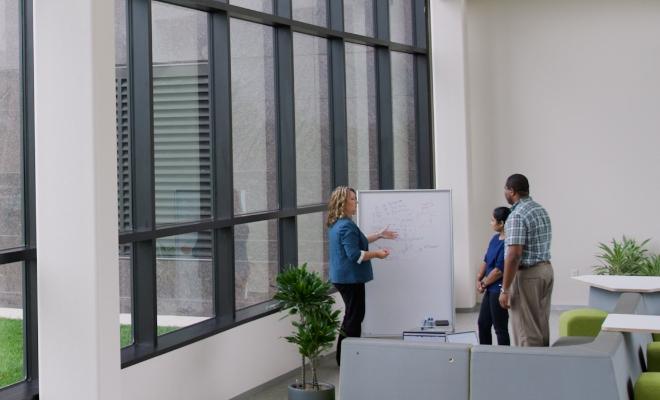 three people in front of a whiteboard