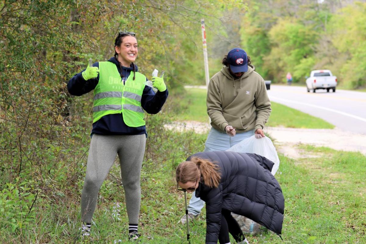 AEG employees and fans participate in the coastal clean-up initiative at Fort Morgan.