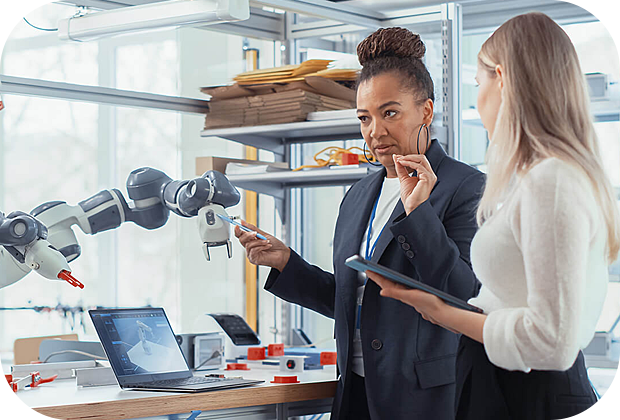 two women standing with robotic equipment