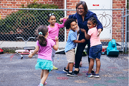 woman hugging 4 small children