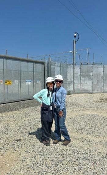 Two people stood together wearing safety hats 