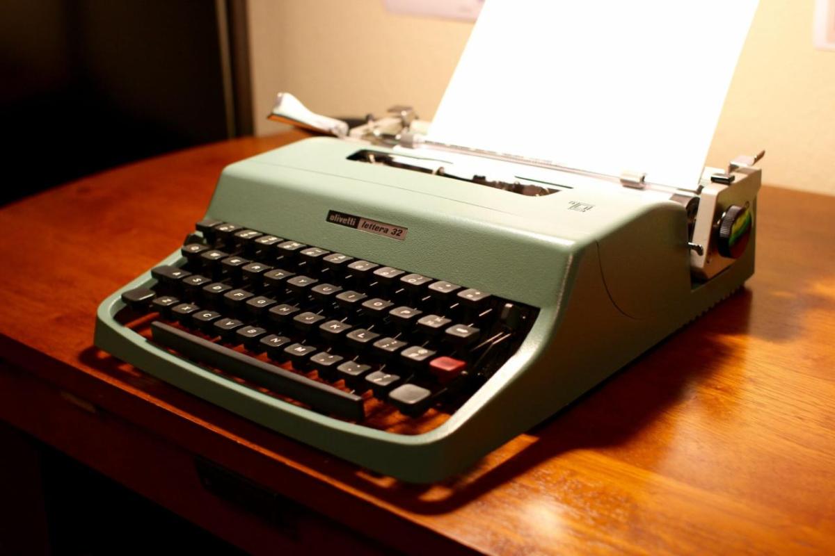 A light green typewriter on a table top