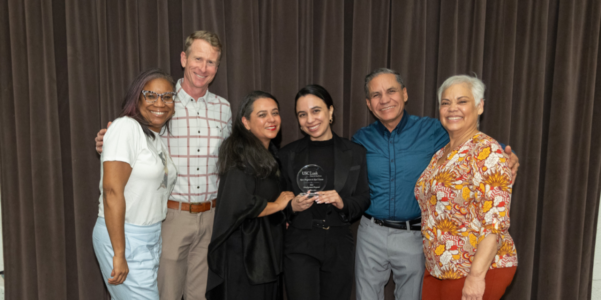 A group of people stood together for a photo holding an award