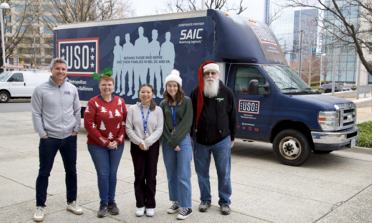 People wearing hats stood in front of a USO van