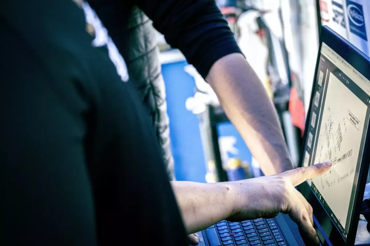 People pointing at a laptop screen