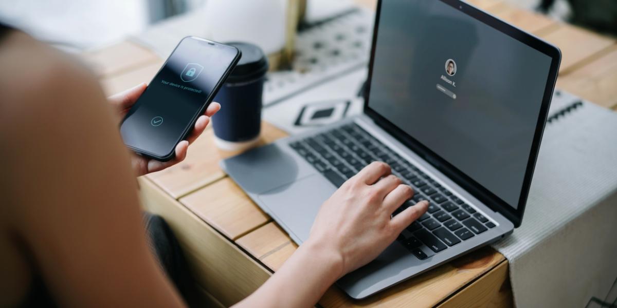 Person working on laptop and phone