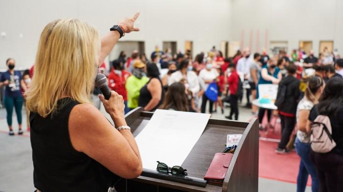 Principal Fairless directs families to stations in the school’s multipurpose room. Credit: Saeed Rahbaran