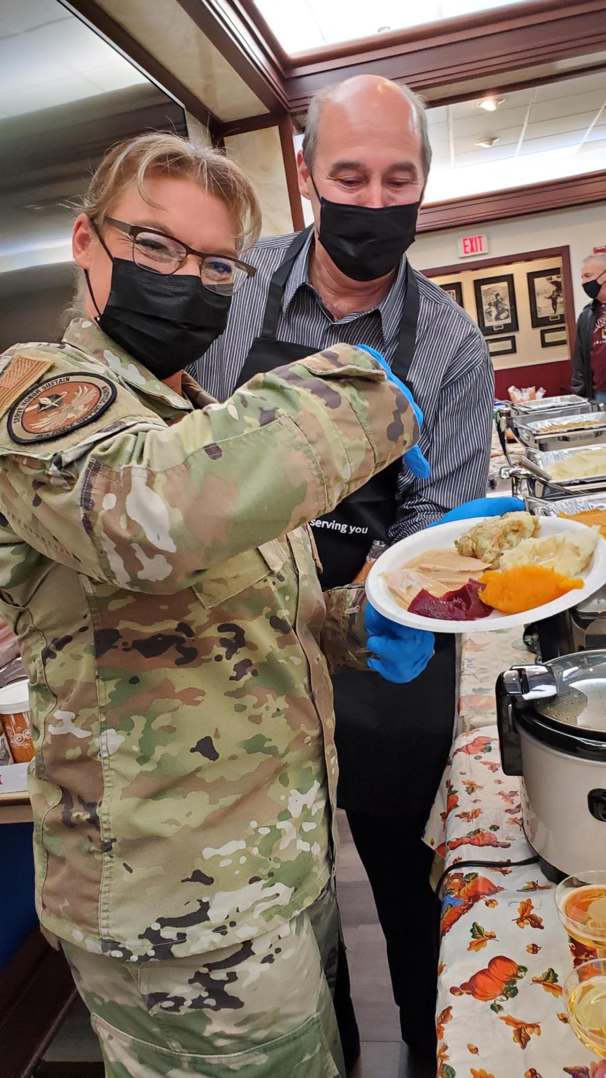 two volunteers holding plate of food 