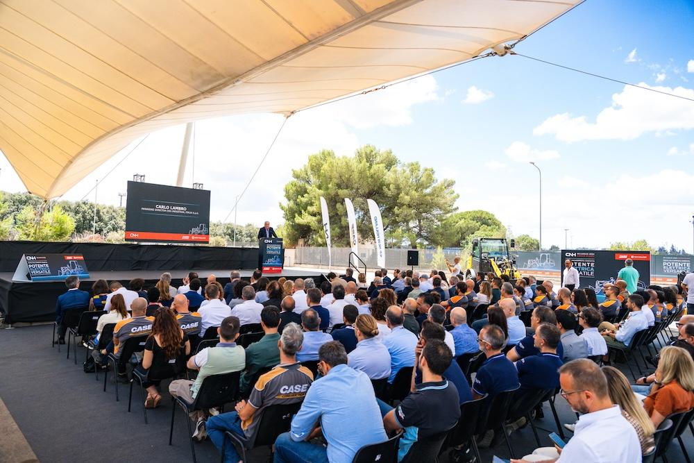 Large group sitting in front of stage in outdoor venue