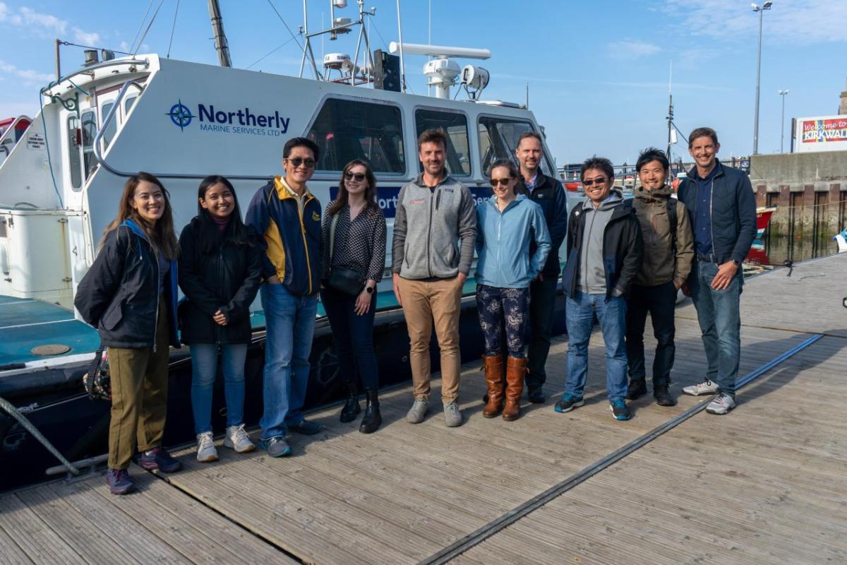 Ian Crossland and group on dock next to a boat