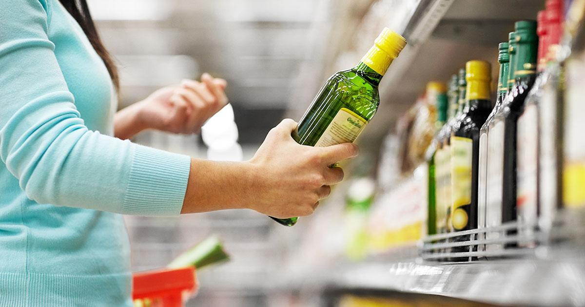 Woman choosing olive oil off shelf