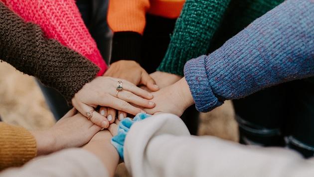 Group of women placing their hands on top of each other